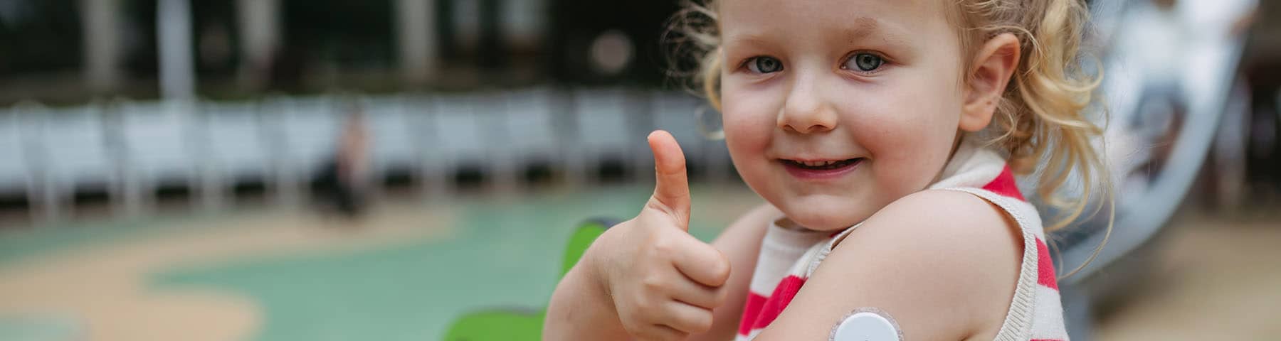 A young girl smiling giving the thumb‘s up.