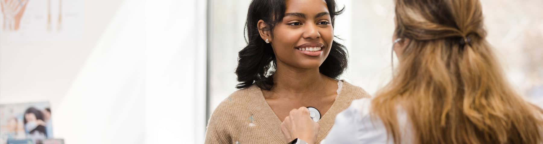 A doctor checking an adolescent female‘s heartbeat.