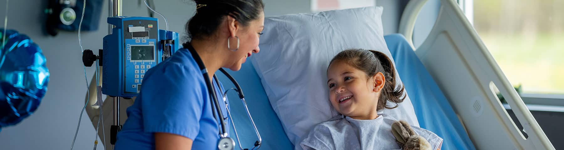 Pediatric nurse with child at bedside.