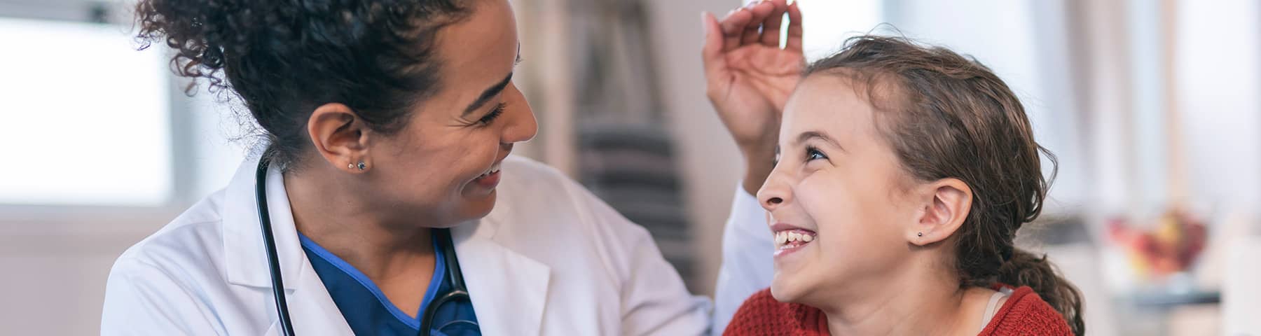 Doctor and young patient smiling at each other during a consultation.