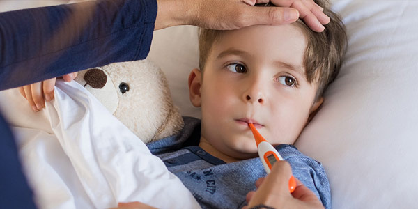 Young boy with a fever getting a temperature check.