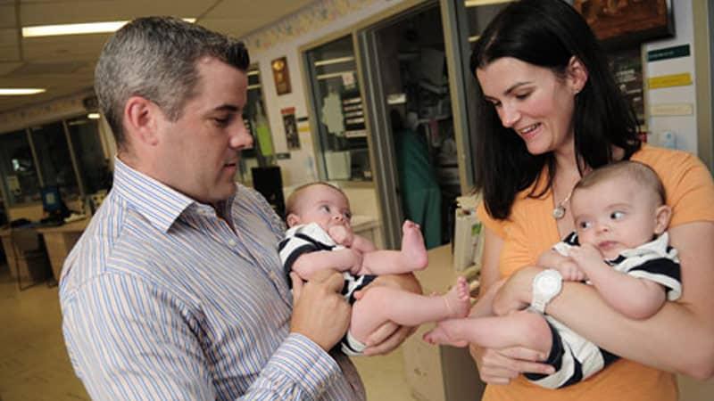 Keegan and Quinlan being held by their parents.