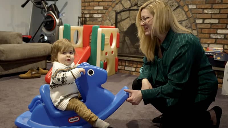 Eric on a toy rocking horse with his mom
